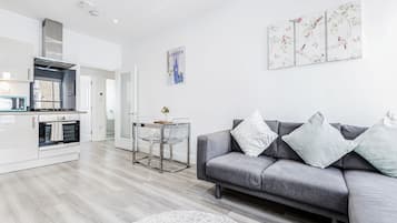 Apartamento ejecutivo, 2 habitaciones | Zona de estar | Una televisión de pantalla plana, Netflix, servicios de streaming