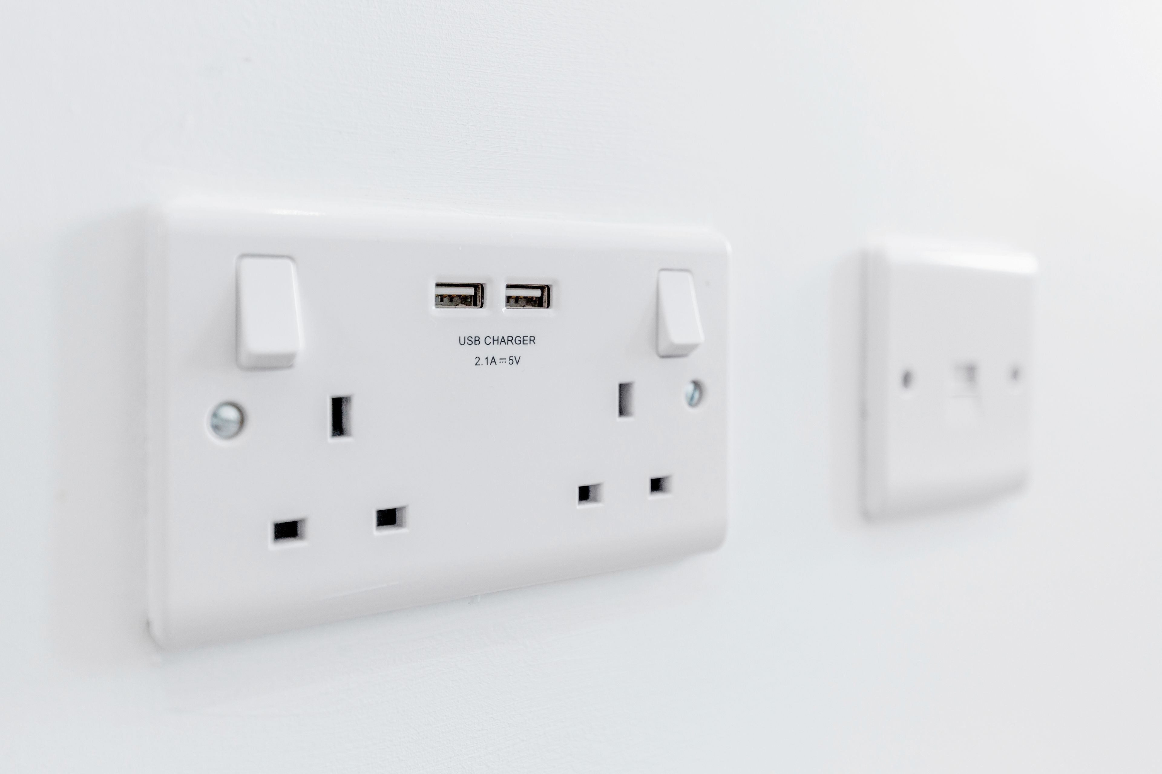 Une prise électrique blanche dotée de ports USB et d’un chargeur USB.