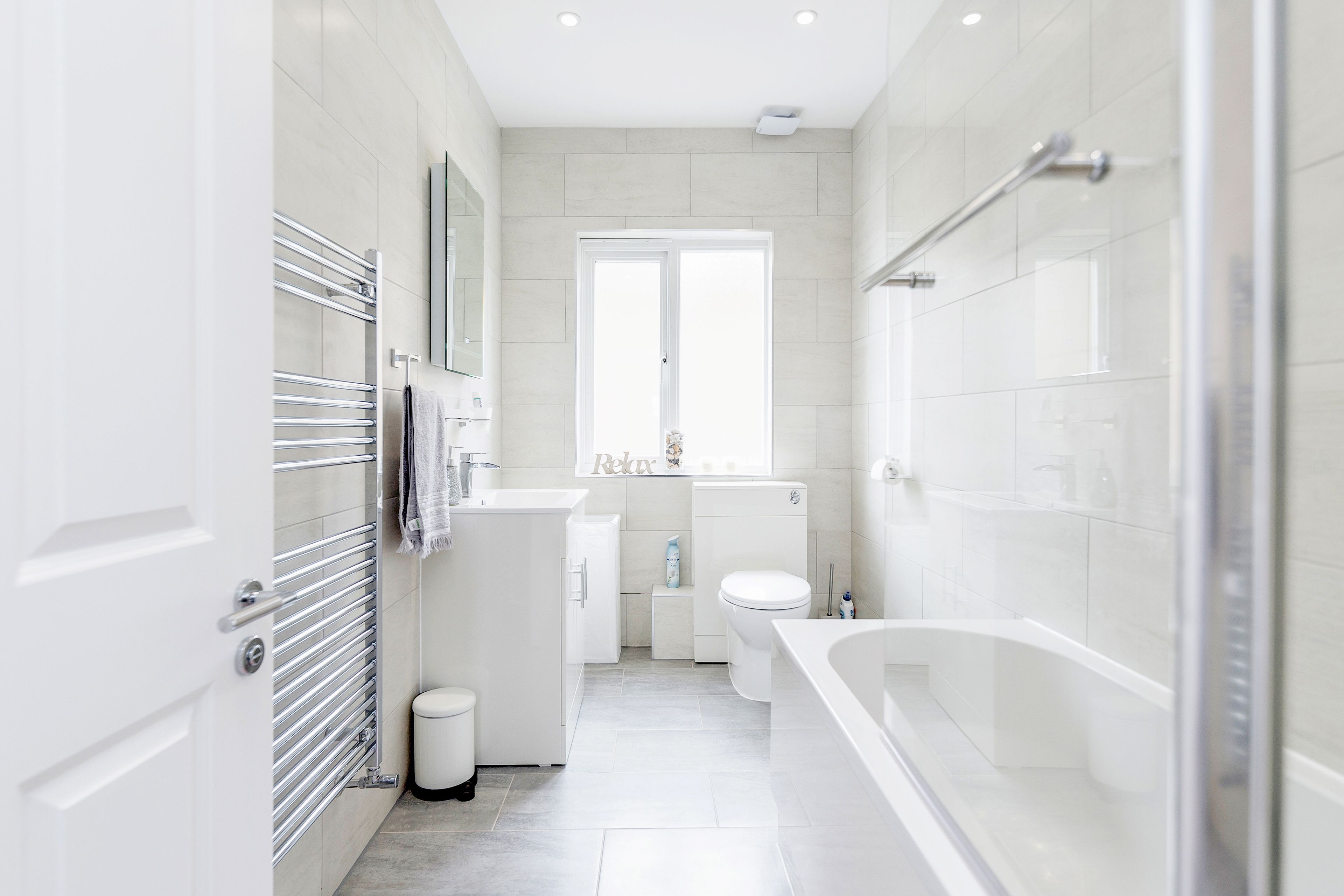 Ein modernes Badezimmer mit Duschkabine aus Glas, einer weißen Badewanne und einem WC.