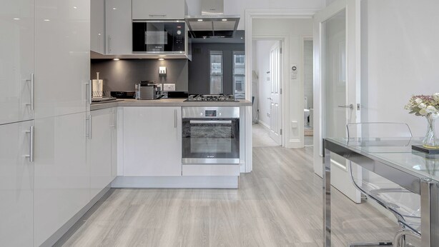 A modern kitchen with white cabinetry, a built-in oven, and a microwave. - 2 Bedroom Portobello Notting Hill Apartment (London)