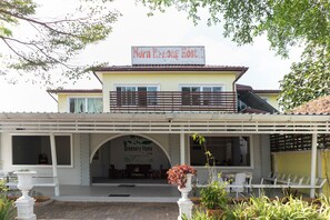 Um edifício de dois andares com uma placa que diz 'Norn Borneo Hostel'.
