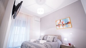 A bedroom with a bed, bedside table, and a painting on the wall. - Panta Rei B&B (Salerno)