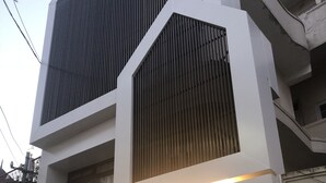 A modern hotel with a prominent sign, a large window, and a closed shutter. - Hotel Aura (Shillong)