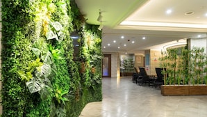A lobby with a green vertical garden wall, a reception desk, and a seating area with chairs. - Felicity Hotel Istanbul  (Istanbul)