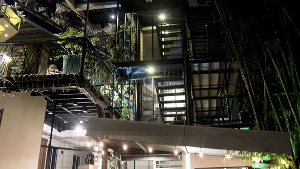 Ein mehrgeschossiges Gebäude mit Außenbereichen, Treppen und Blumentöpfen.