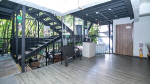 Ein modernes Interieur mit einer Treppe, einem Empfangstresen und einer Bank.