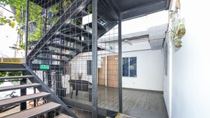 Ein modernes Interieur mit einer Metalltreppe, Holzboden und Blick ins Freie.