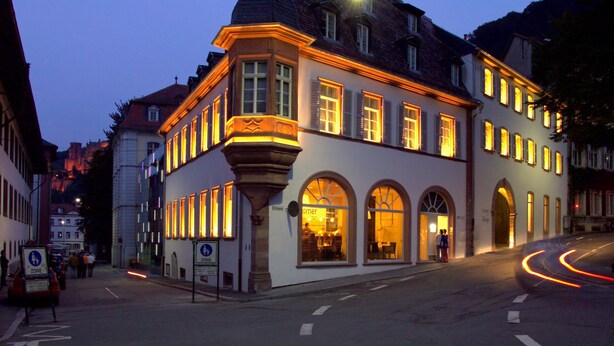 A historic building with a corner turret, large windows, and a street view at dusk. - Arthotel Heidelberg (Heidelberg)