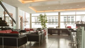 A modern hotel lobby with a staircase, seating areas, and large windows. - Arthotel Heidelberg (Heidelberg)