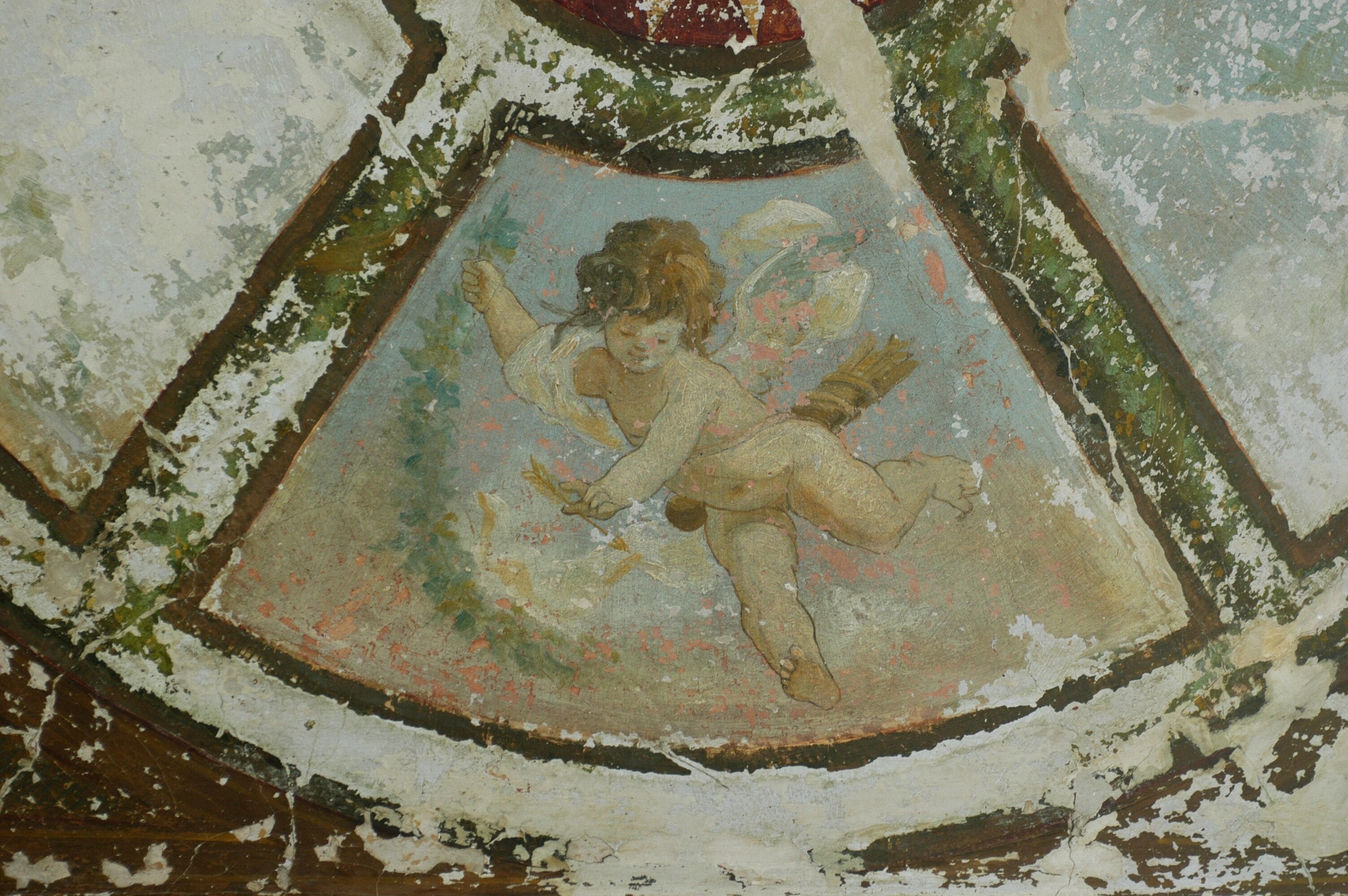 A fresco of a cherub on a ceiling.