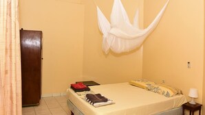 A room with a bed, a wardrobe, and a mosquito net. - Macsapartment (Paramaribo)