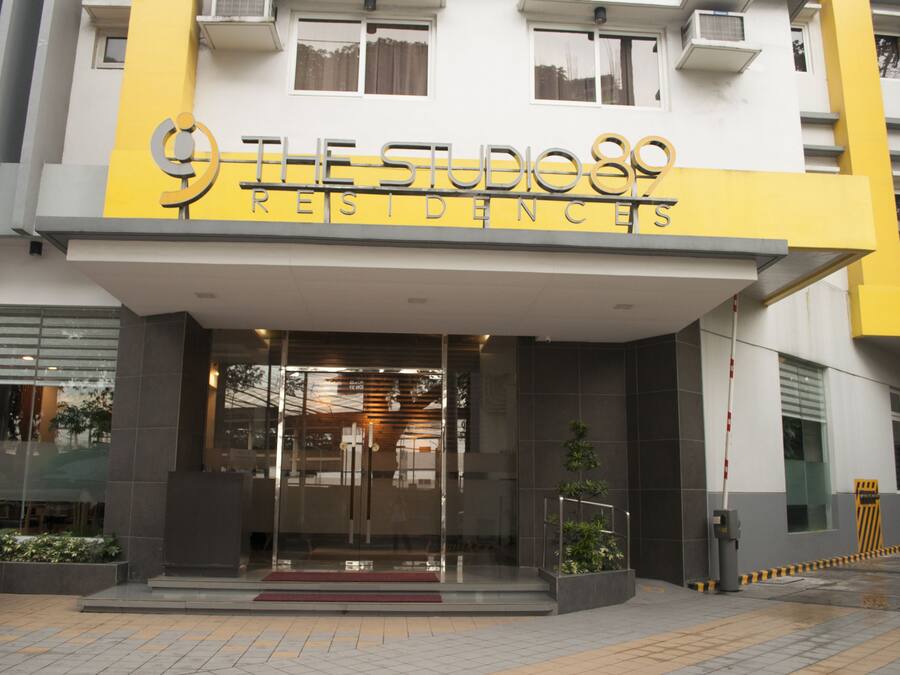 A building with a sign reading "THE STUDIOS RESIDENCES."