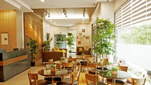A modern hotel lobby with multiple seating areas, a reception desk, and large windows providing natural light. - Studio 89 Katipunan QC (Quezon City)