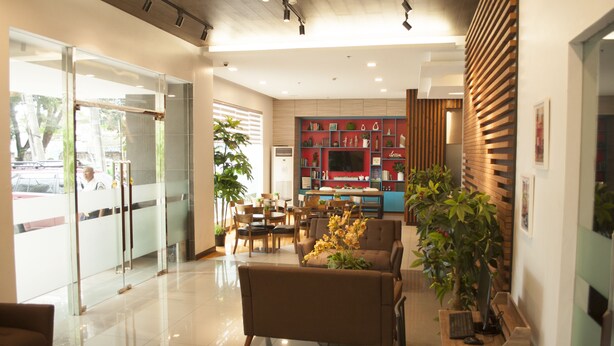 A modern lobby with a seating area, a reception desk, and a television screen. - Studio 89 Katipunan QC (Quezon City)