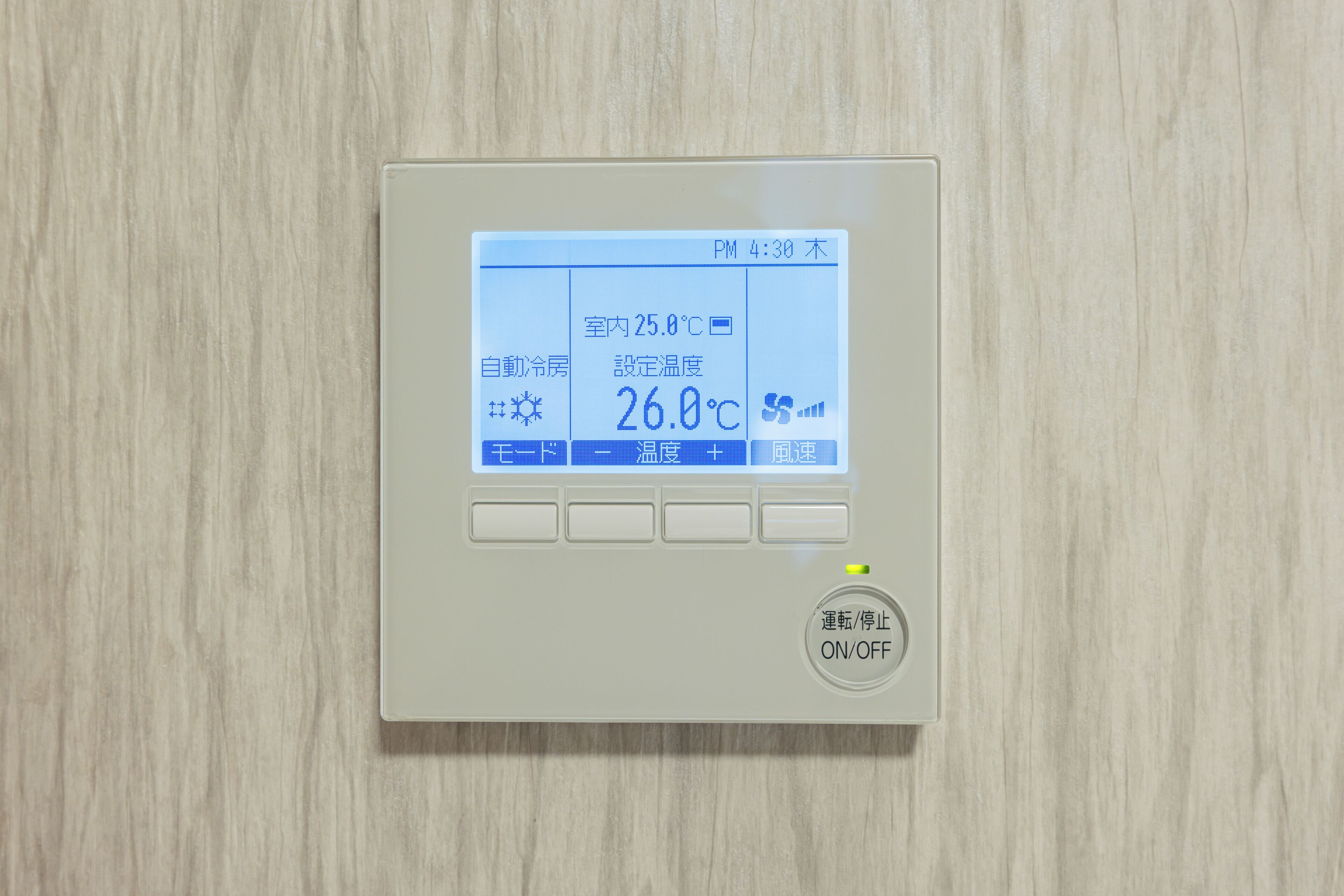 A digital thermostat with a display showing room temperature and a control panel with buttons.