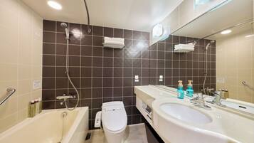 A modern bathroom with a bathtub, toilet, and sink, featuring a large mirror and tiled walls.