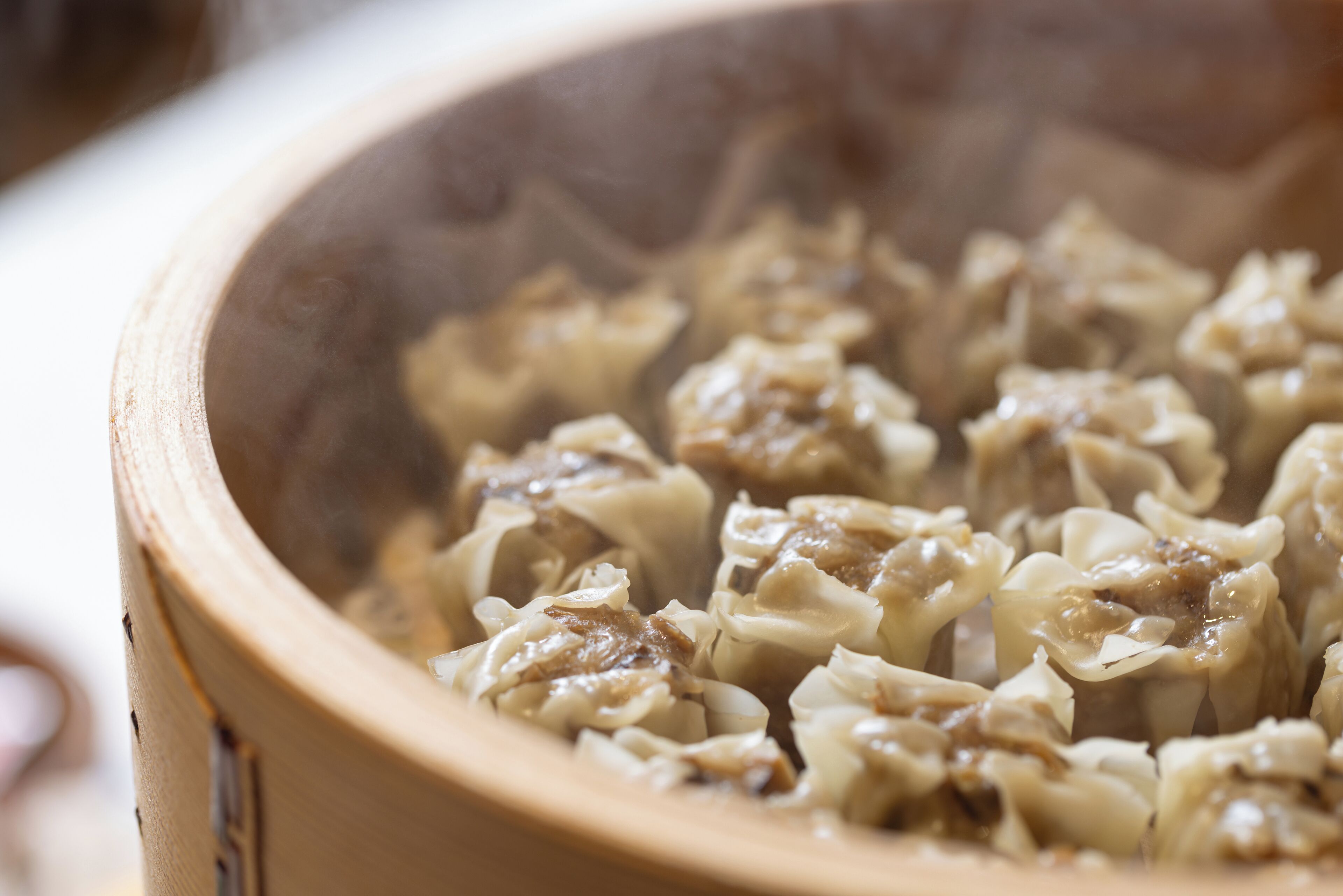 A close-up of a bamboo steamer filled with dumplings.