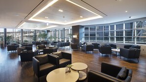A spacious lobby with modern furniture, large windows, and a view of the cityscape. - Asti Hotel Busan Station (Busan)