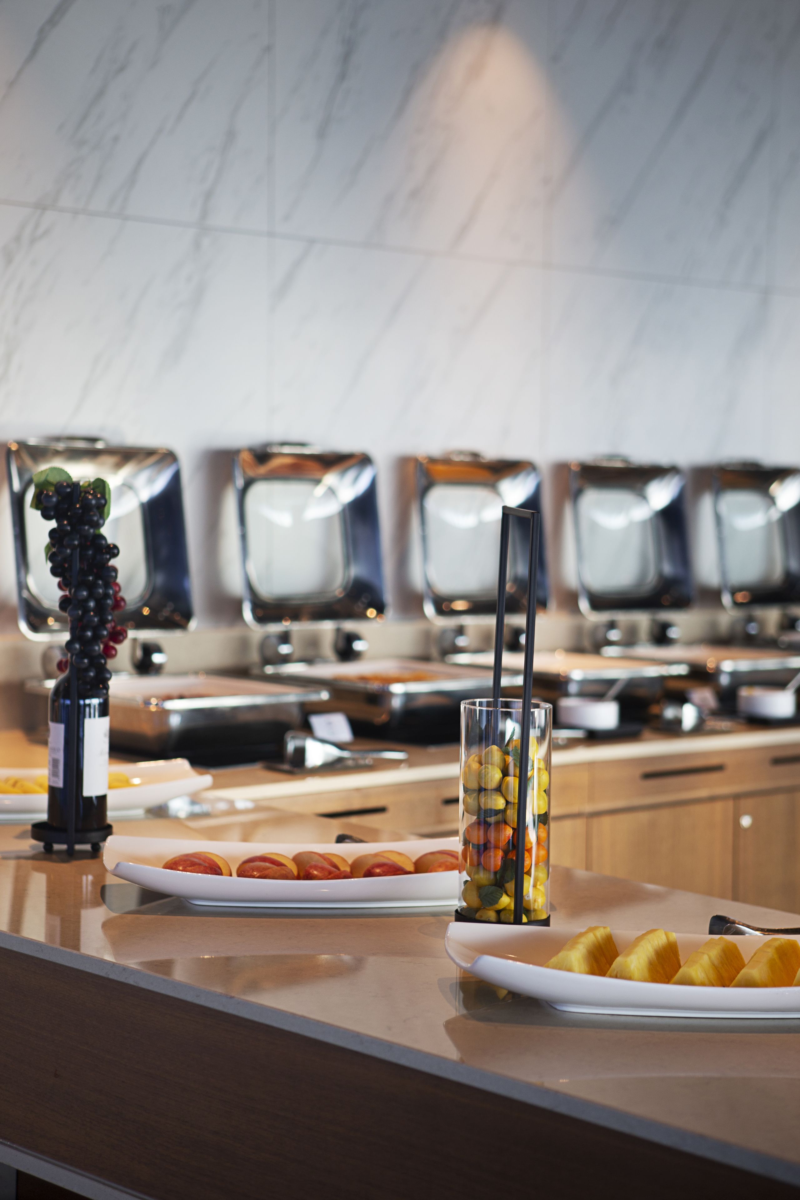 Een buffet met diverse etenswaren en een fles wijn.
