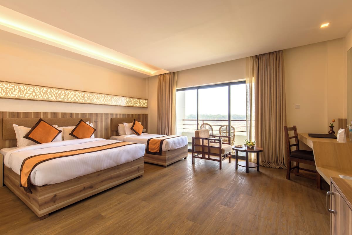 A hotel room with two beds, a desk, and a chair.