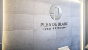 A wall with the sign "PLEA DE BLANC HOTEL & RESIDENCE" and a logo. - Plea De Blanc (Busan)