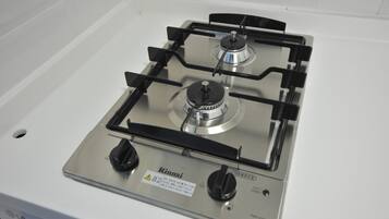 A stainless steel gas stove with four burners and two knobs, labeled "Rinnai."