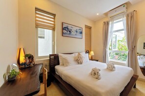 A hotel room with a bed, bedside table, lamp, and a window with curtains. - Hoi An Green Town House Homestay (Da Nang)