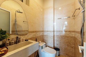A bathroom with a shower, toilet, sink, and mirror. - Hoi An Green Town House Homestay (Da Nang)