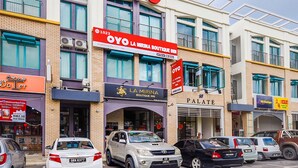 Un immeuble à plusieurs étages, sur lequel on peut voir une grande enseigne « OYO », indiquant qu’il s’agit d’un hôtel de charme.