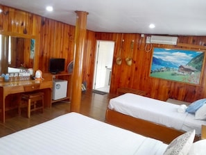 Une chambre à l’ambiance boisée, comprenant un lit, un bureau et un téléviseur.