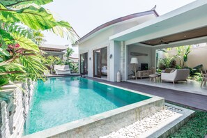 A modern pool area with a clear pool, surrounded by lush greenery and a well-maintained garden. - Daun Lebar Villas (Payangan)