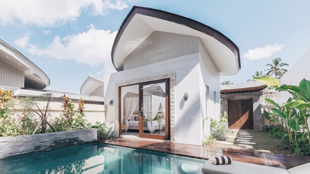 A modern resort with a swimming pool, outdoor seating, and a private cabana with a glass door. - Daun Lebar Villas (Payangan)