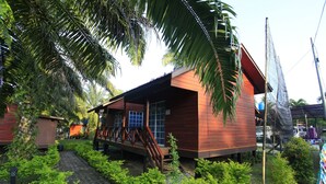 Een houten huis met een veranda en een trap naar de ingang.
