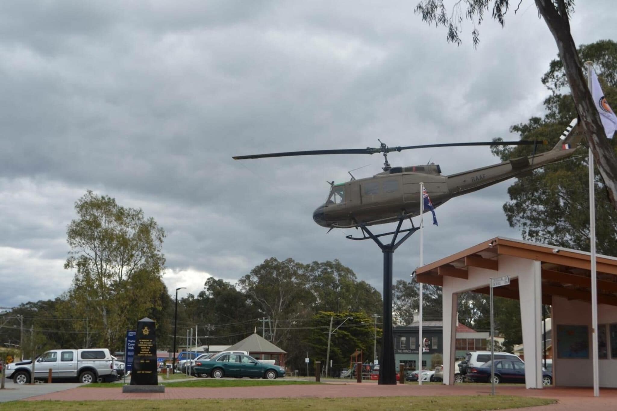A helicopter parked on a helipad with a building in the background.