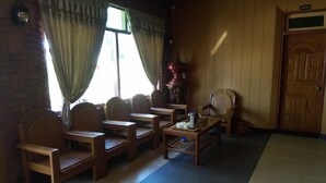 A room with wooden furniture, including chairs and a table, and a door marked with the number 106. - Golden Fish Motel (Nyaungshwe)