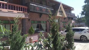 A two-story building with a balcony, a car parked in front, and a sign that reads "Motel". - Golden Fish Motel (Nyaungshwe)