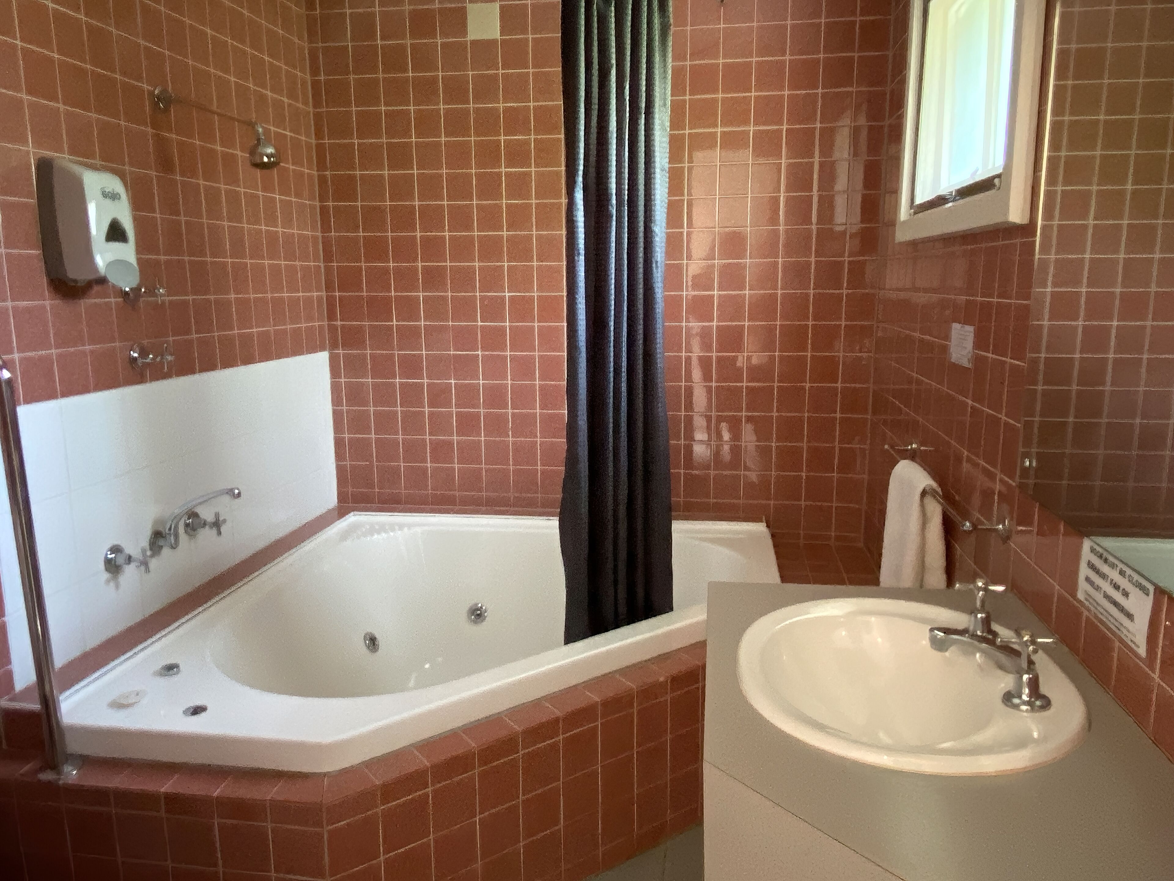 Une salle de bain avec une baignoire, un lavabo et un rideau de douche.