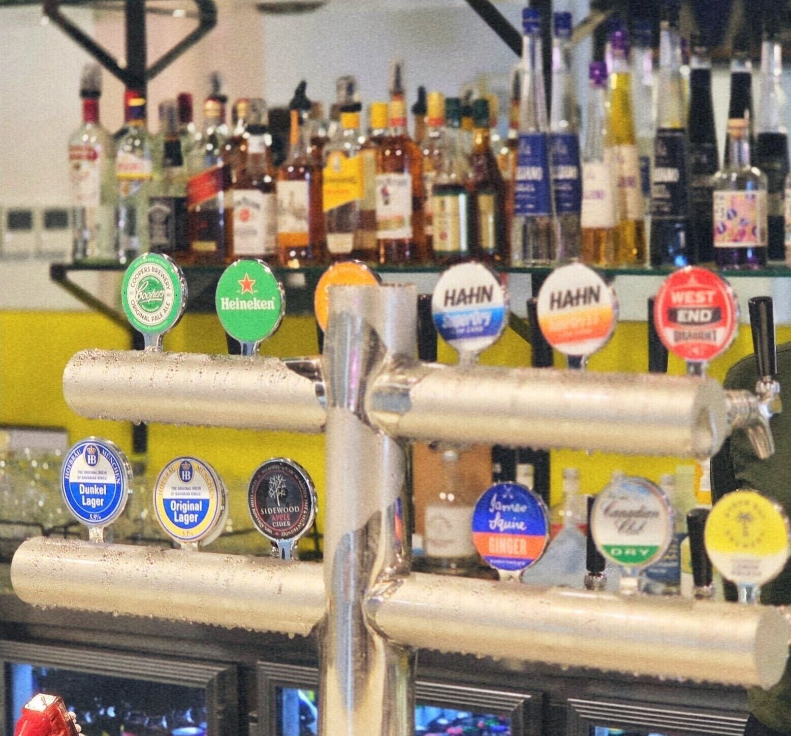 A bar with various beer taps including brands like Heineken, Dunkel Lager, and Apple Cider.
