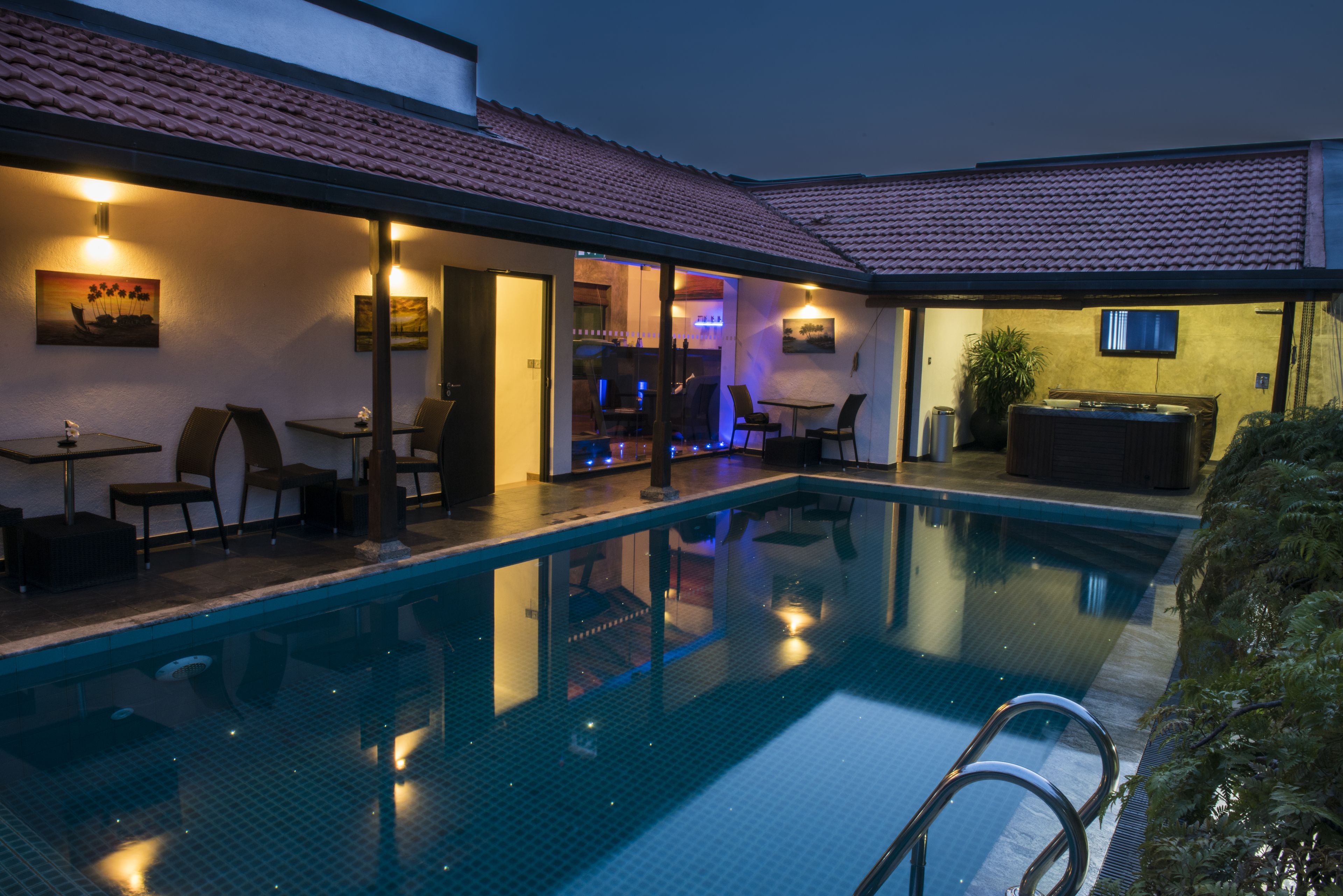 Een binnenzwembad, een zwembad op het dak en ligstoelen