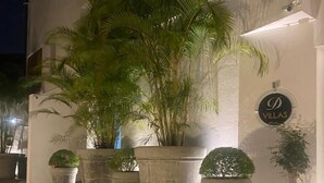 A building with a sign reading "D Villas" and several large potted plants on the ground floor. - D Villas (Sri Jayawardenepura Kotte)