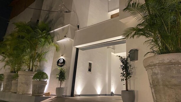 A modern building with a large entrance, potted plants, and a sign that reads "D Villas". - D Villas (Sri Jayawardenepura Kotte)