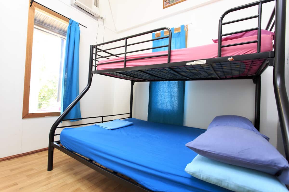 A bunk bed with a blue mattress and a single bed with a blue mattress.