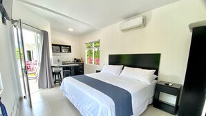 A hotel room with a bed, a desk, and a kitchenette. - Uvita Paradise (Bahía Ballena)
