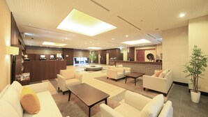 A spacious lobby with multiple seating areas, a reception desk, and a large plant. - Richmond Hotel Utsunomiya Ekimae (Utsunomiya)