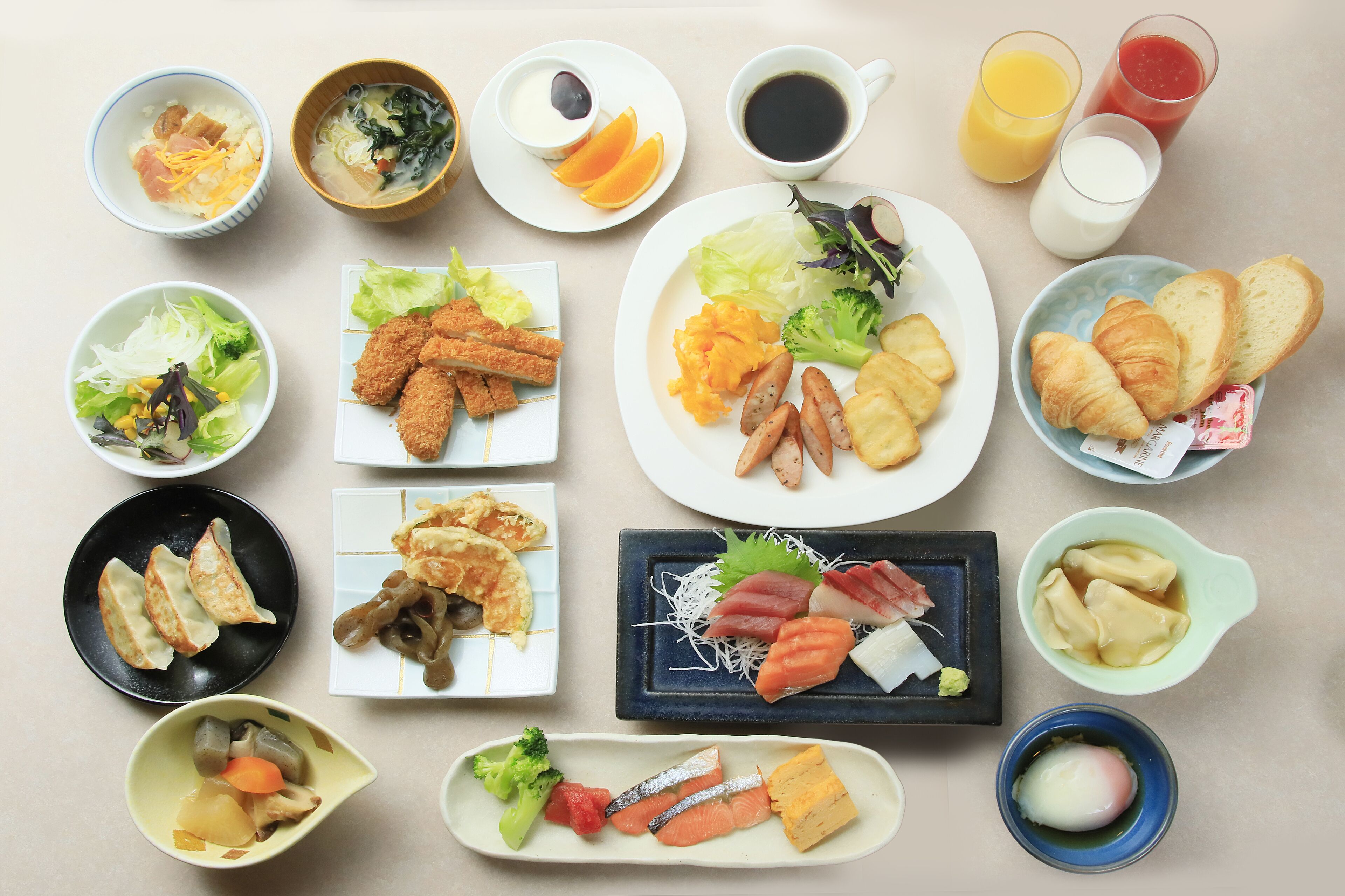 A variety of dishes including sushi, sashimi, and tempura arranged on a table.