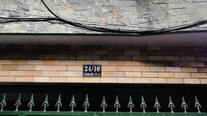 Ein mehrstöckiges Gebäude mit Balkon, einer Zimmernummer-Beschilderung und einer Ziegel-Fassade.