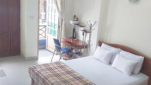 Ein Schlafzimmer mit Bett, Schreibtisch, Stuhl und Kleiderschrank.
