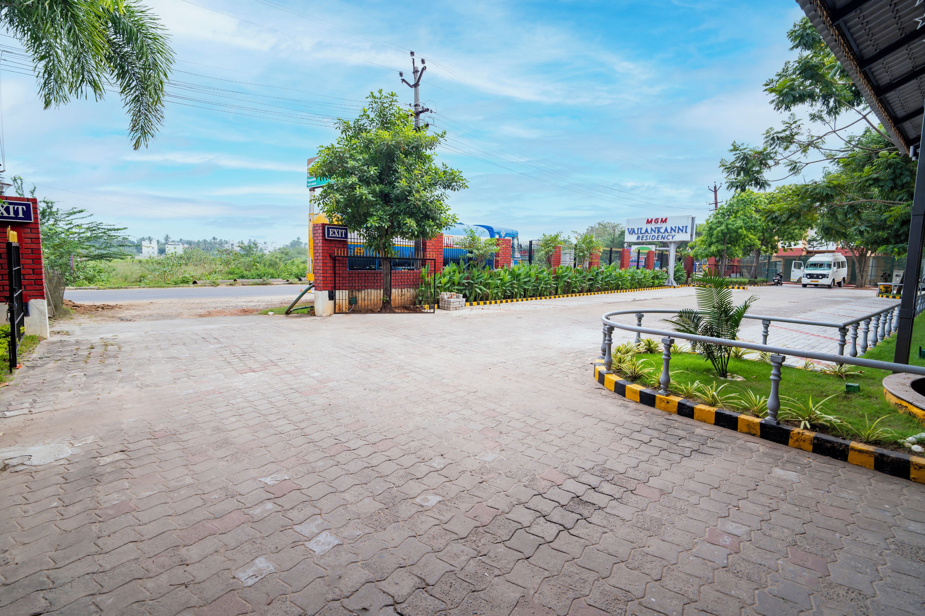 A gated entrance with a brick pathway leading to a parking area.