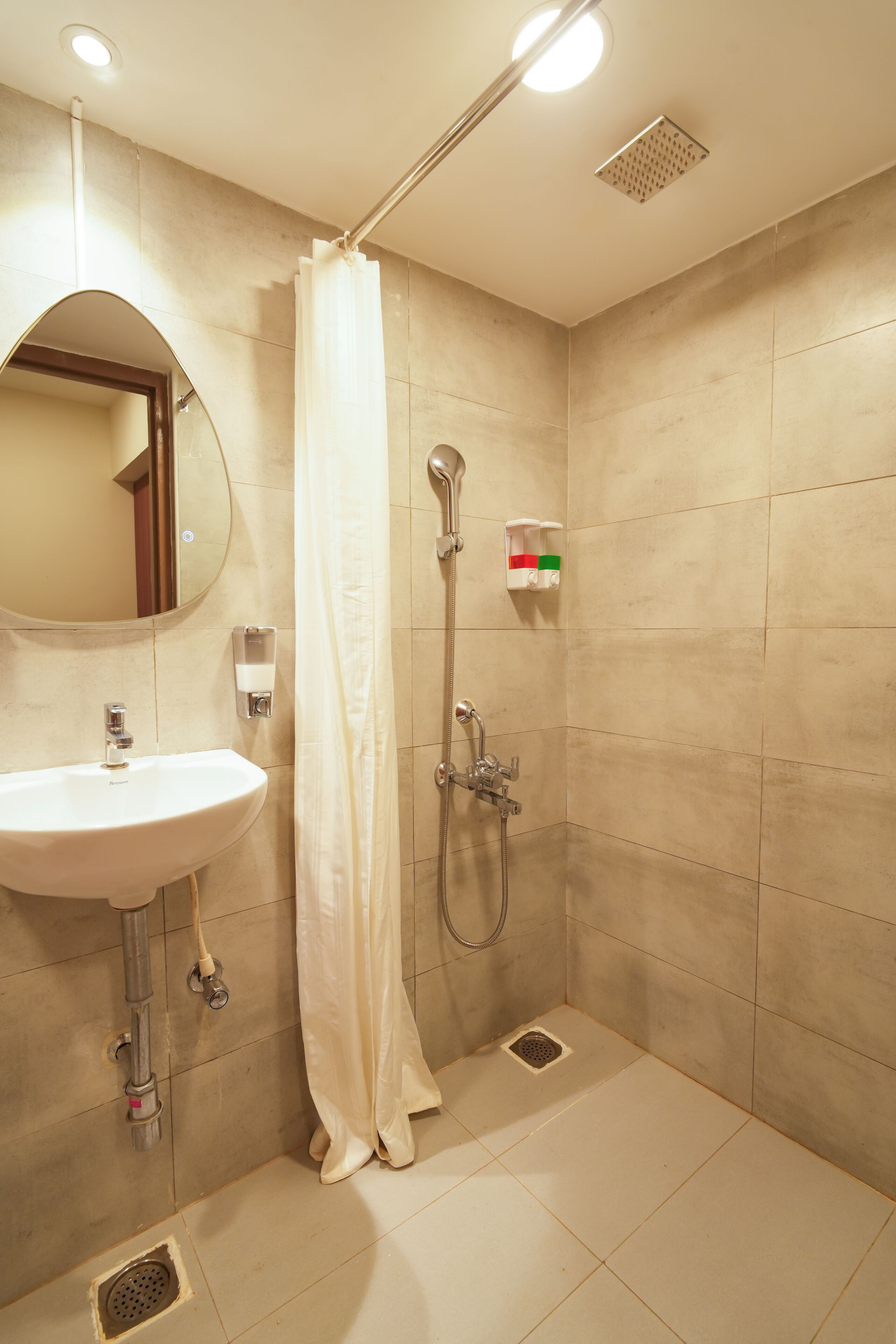 Een badkamer met een wastafel, spiegel, douche en toilet.