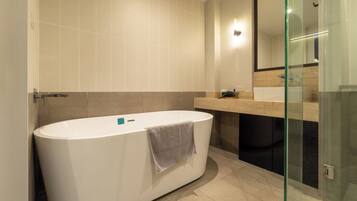 A modern bathroom with a freestanding bathtub, a glass shower enclosure, and a large mirror.